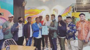 Ketum Alvin saat menyerahkan SK kepada La Ode Muhammad Izat (jas KNPI) didampingi pengurus KNPI Sultra